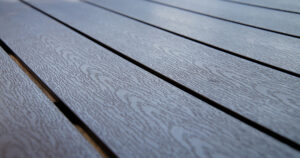 Gros plan de lames de terrasse en bois composite gris avec un veinage imitation bois