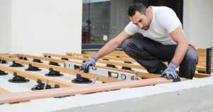 artisan construisant une terrasse sur plots en bois