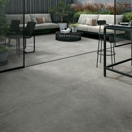Terrasse extérieure en carrelage grès cérame gris 80x80 cm posé sur plots avec salon de jardin