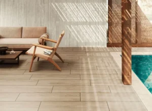 Plage de piscine en dalles grès cérame effet bois clair 30x120 avec salon de jardin sous pergola